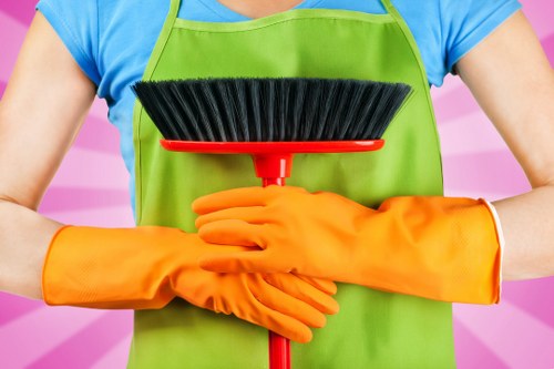 Cleaner wearing PPE while servicing an oven in a Battersea home